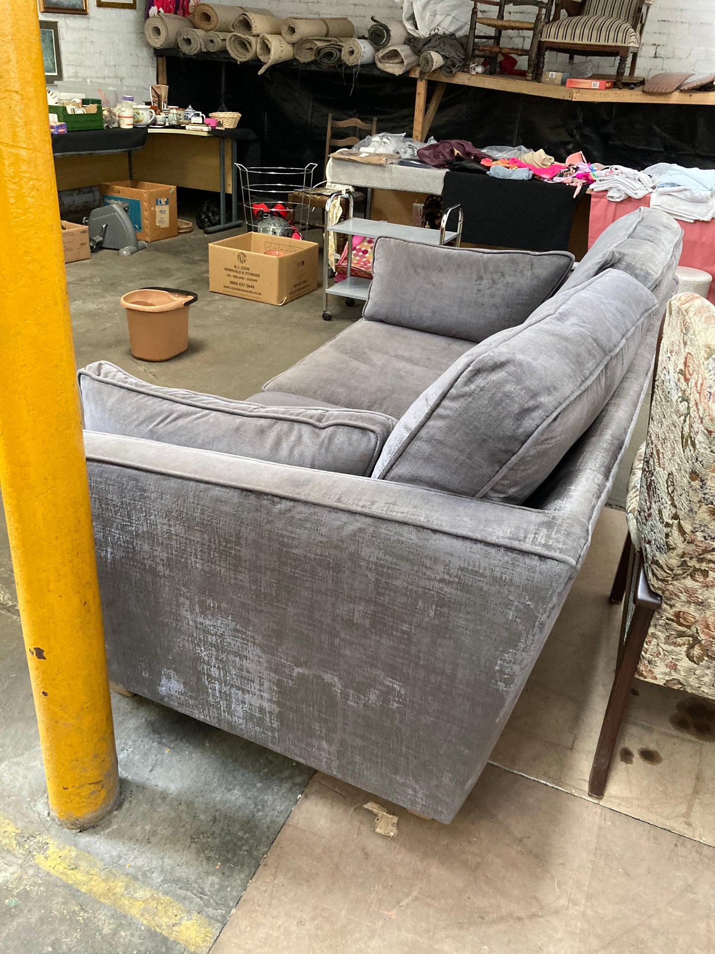 A large grey upholstered settee with cushions