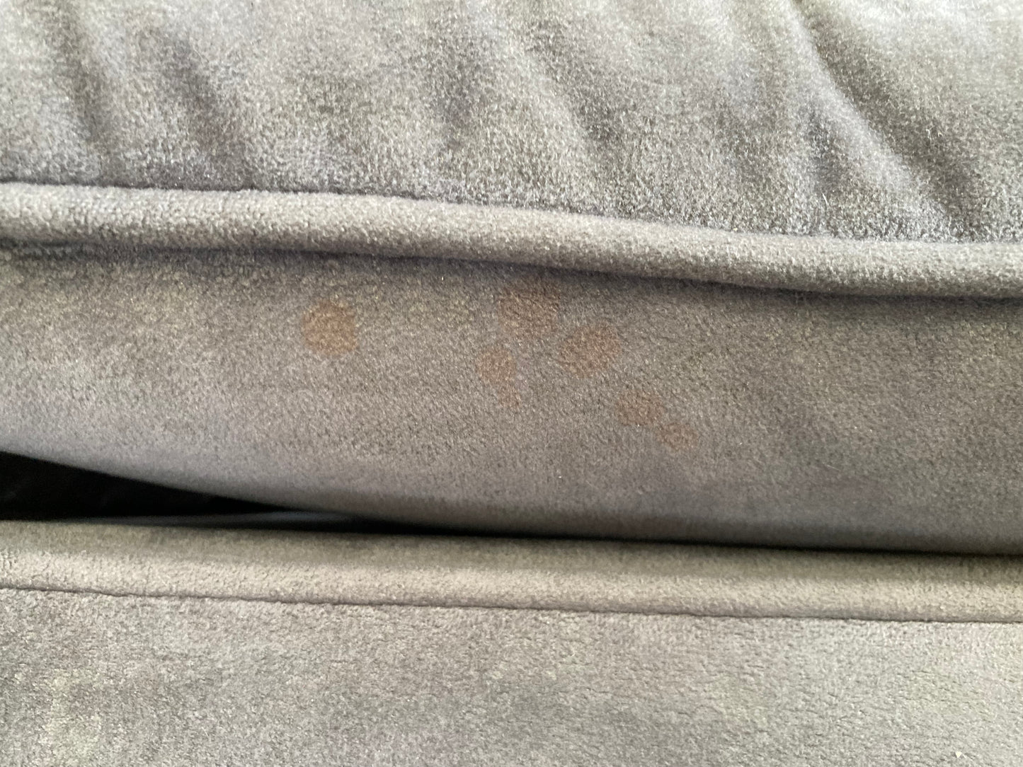 A large grey upholstered settee with cushions