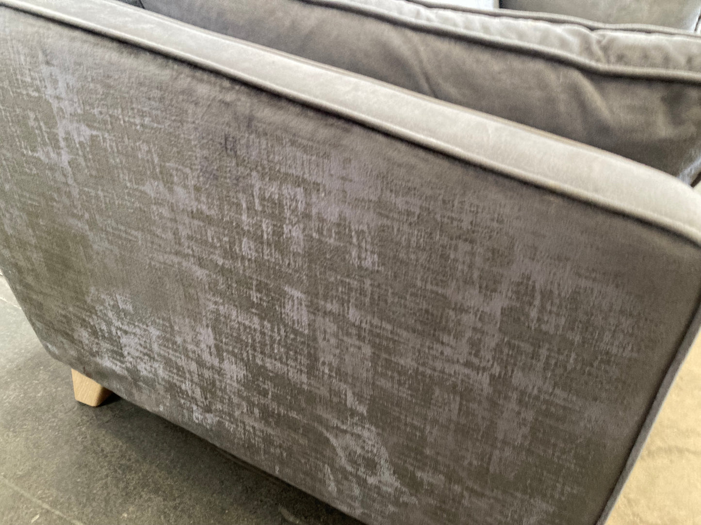 A large grey upholstered settee with cushions