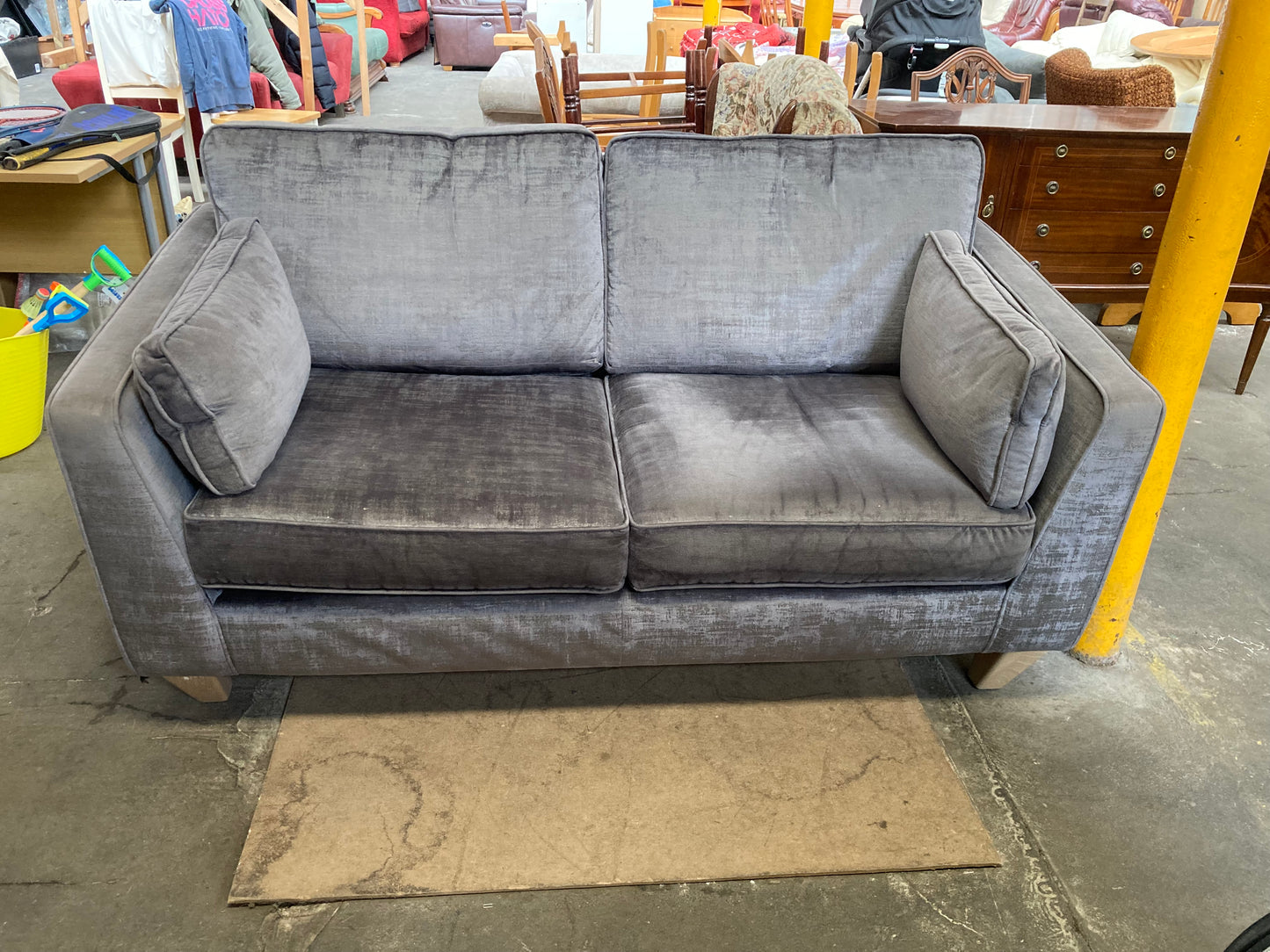 A large grey upholstered settee with cushions