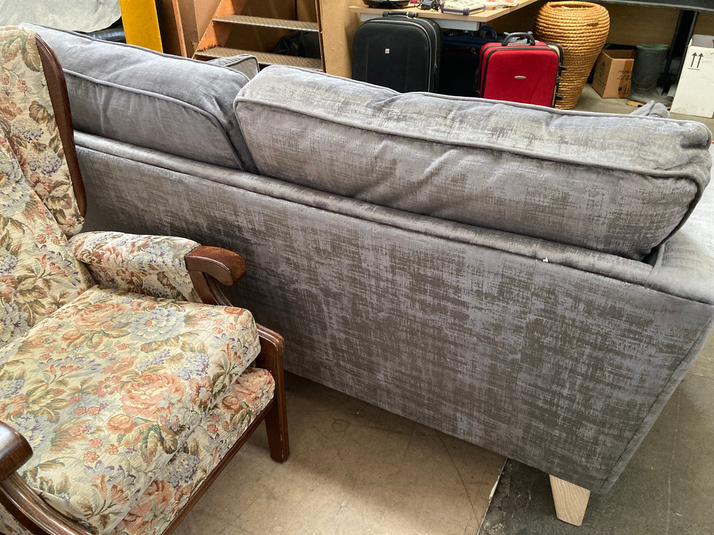 A large grey upholstered settee with cushions